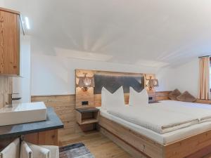 a bedroom with a large bed and a sink at Beautiful apartment in Brixen in the Thale in Brixen im Thale