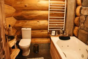 un baño con inodoro y bañera en ECO HOUSES ART OF LIVING - Еко къщи изкуството да живееш, en Pamporovo 45 fotos más