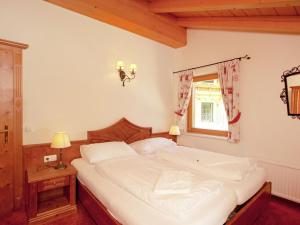 a bedroom with a large white bed and a window at Chalet apartment in Saalbach-Hinterglemm in Saalbach-Hinterglemm