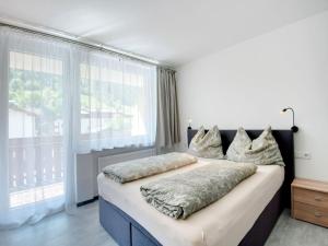 a bedroom with a large bed and a large window at Apartment Bergblick Anna in Kaprun with balcony in Kaprun