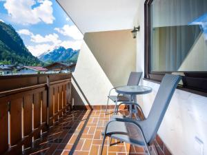 a balcony with two chairs and a table and a window at Apartment Bergblick Anna in Kaprun with balcony in Kaprun