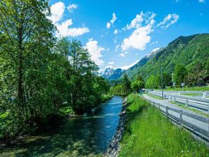a river next to a road with mountains in the background at Apartment Bergblick Anna in Kaprun with balcony in Kaprun