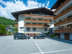 dwa samochody zaparkowane na parkingu przed budynkiem w obiekcie Chalet in Kaprun near Ski Slopes w Kaprunie