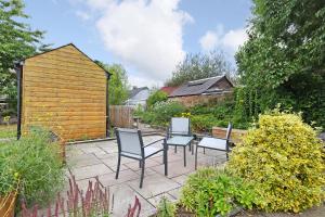 a patio with chairs and a table in a garden at One bed apartment in the heart of Innerleithen in Innerleithen