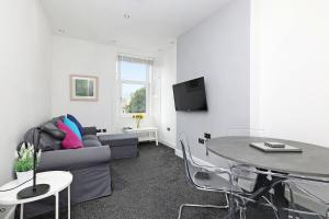 a living room with a couch and a table at One bed apartment in the heart of Innerleithen in Innerleithen