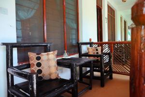 dos sillas negras y una mesa en un porche en Darwesh Nyumba Lodge, en Nungwi 52 fotos más