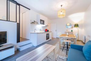 een keuken en een woonkamer met een bank en een tafel bij Woody Cocon by Plaza - Proche Disneyland Paris in Montévrain