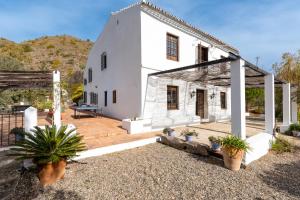 a white house with potted plants in front of it at Finca Arroyo de las Adelfas in Málaga