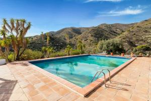 a swimming pool with a mountain in the background at Finca Arroyo de las Adelfas in Málaga