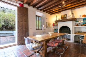 a dining room with a wooden table and a fireplace at Finca Arroyo de las Adelfas in Málaga