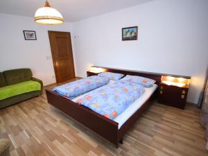 ディーンテン・アム・ホーホケーニッヒにあるSpacious flat near the ski area in Salzburgのベッドルーム(大型ベッド1台、ソファ付)
