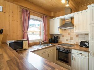 a kitchen with white cabinets and a sink and a window at Chalet near the Kreischberg ski area in Stadl an der Mur