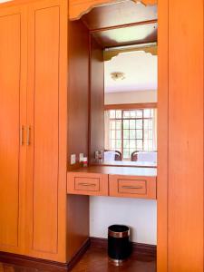 a kitchen with a sink and a mirror at Oilepo Cottage in Naivasha