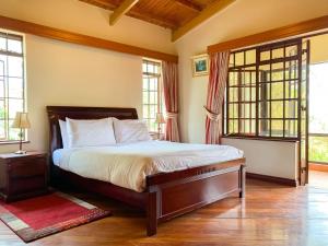 a bedroom with a bed in a room with windows at Oilepo Cottage in Naivasha