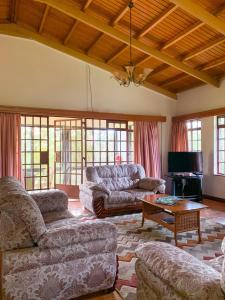 een woonkamer met banken en een tafel bij Oilepo Cottage in Naivasha