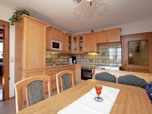 eine Küche mit Holzschränken und einem Holztisch in der Unterkunft Snug Holiday Home in Sankt Johann im Pongau with Garden in Wagrain