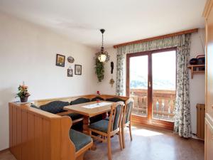 ヴァークラインにあるSnug Holiday Home in Sankt Johann im Pongau with Gardenのダイニングルーム(テーブル、ソファ、窓付)