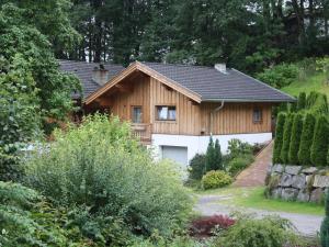 ピーゼンドルフにあるSpacious Apartment near Ski Area in Piesendorfの庭のガレージ付き木造家屋