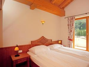 1 dormitorio con cama blanca y ventana en Chalet apartment in ski area Saalbach-Hinterglemm en Saalbach Hinterglemm