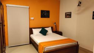 um quarto com uma cama com uma parede laranja em Marvel Hills Kandy em Kandy