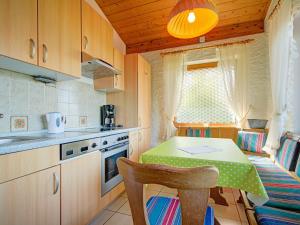 een keuken met een tafel en een eetkamer bij Quaint Chalet with Garden Terrace Fireplace Play Equipment in Iselsberg