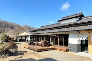 a house with a deck and a patio at 八ヶ岳FUJIYAMAテラス寛道 in Hokuto