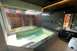 北斗的住宿－八ヶ岳FUJIYAMAテラス寛道，一间带按摩浴缸和窗户的浴室