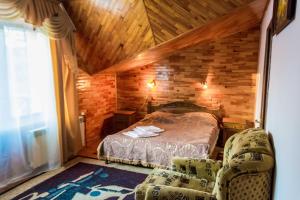 a bedroom with a bed and two chairs in a room at Приозерний заїзд in Rulevo