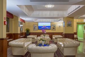 a waiting room with couches and a tv at Hotel San Michele in Milazzo