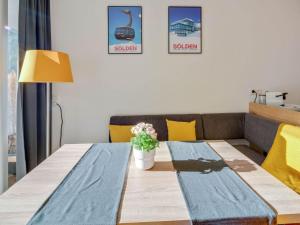 a dining room table with a blue table runner and a couch at Cosy flat in Zweiselstein with Garden in Sölden