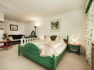 ein Schlafzimmer mit einem grünen Bett und einem Sofa in der Unterkunft Apartment in Bad Hofgastein with sauna in Bad Hofgastein