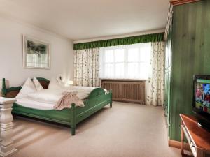ein Schlafzimmer mit einem grünen Bett und einem TV in der Unterkunft Apartment in Bad Hofgastein with sauna in Bad Hofgastein