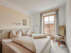 1 dormitorio con cama, ventana y silla en Attractive apartment in Hainzenberg with ski room, en Hainzenberg