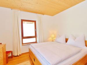 - une chambre avec un lit blanc et une fenêtre dans l'établissement Flat directly on the ski slope with valley view, à St. Johann in Tirol