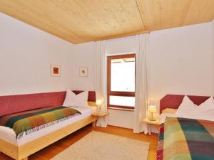 - une chambre avec 2 lits et une fenêtre dans l'établissement Flat directly on the ski slope with valley view, à St. Johann in Tirol