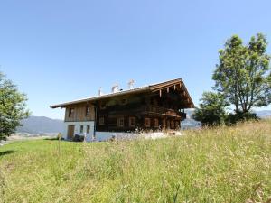 une vieille maison sur une colline dans un champ dans l'établissement Flat directly on the ski slope with valley view, à St. Johann in Tirol