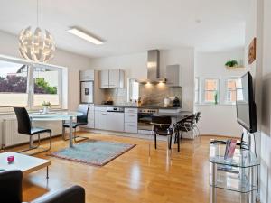 Una cocina y una sala de estar con mesa y sillas. en Apartment Innsbruck near Bergisel Ski Jump, en Innsbruck