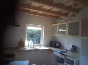 a kitchen with a sink and a window at Domek Jana in Mrągowo +5 photos