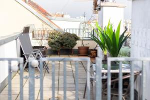 a patio with chairs and plants on a balcony at Sky Apartments Vienna in Vienna