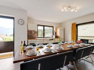 a dining room with a large table and a kitchen at Holiday apartment in Koetschach Mauthen with sauna in Kötschach