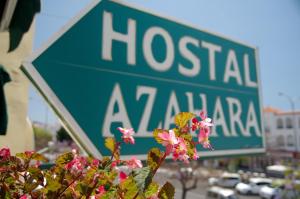 a green street sign in front of a hospitalzaza sign at Hostal Azahara in Nerja