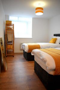 a bedroom with two beds and a window at Olu Apartments Belem Tower Sefton Park in Liverpool