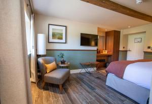 a hotel room with a bed and a chair at The Falcon Hotel in Northampton +52 photos