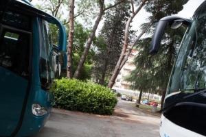 a bus parked next to a tree in a parking lot at AUTO PARK HOTEL con Ristorante interno e grande parcheggio gratuito in Florence