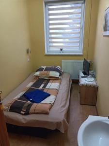 a bedroom with a bed and a sink and a window at Motel Sportowy OSiR Jawor in Jawor