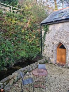 un patio con mesa y sillas junto a un edificio en The Well house, en Ilfracombe