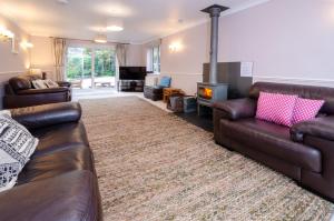 a living room with two leather couches and a fireplace at Wansfell in Ambleside