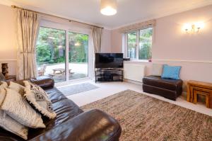 a living room with a leather couch and a television at Wansfell in Ambleside