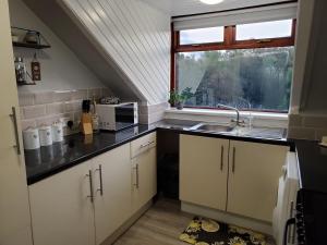 a small kitchen with a sink and a window at Carvetii - Mayhaven House - Tranquil Cul-de-Sac - 2 Bedrooms, Sleeps 4 Guests in Dunfermline