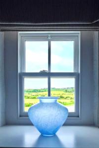 a blue vase sitting in front of a window at Blas Mwy Black Lion B and B in Holyhead